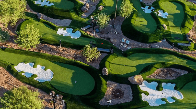Aerial view of a miniature golf course with bright green putting areas